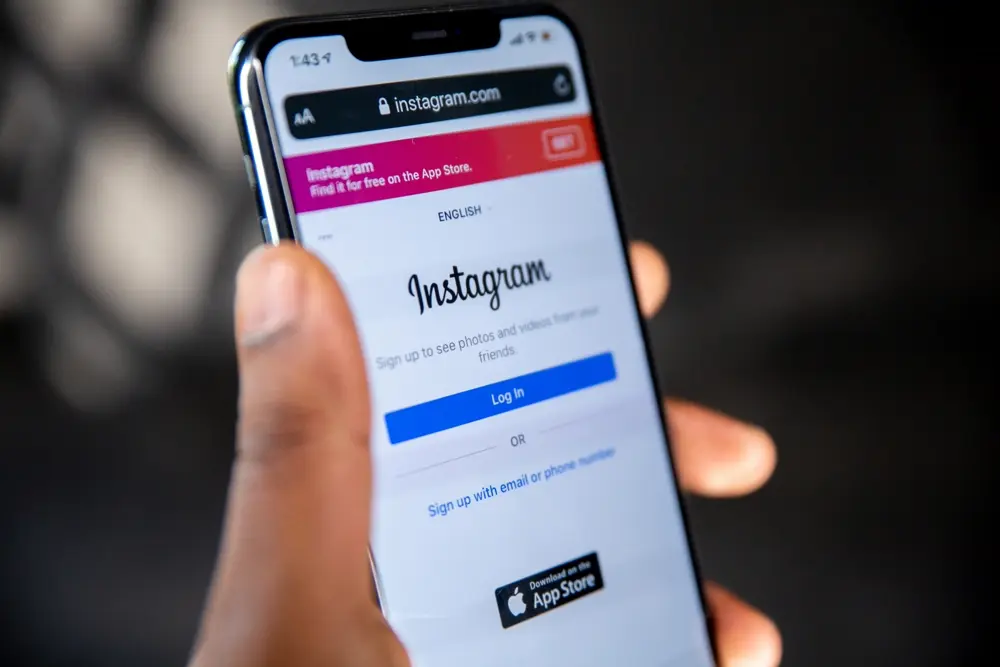 Person holding a phone with the Instagram app open, illustrating buying Instagram followers