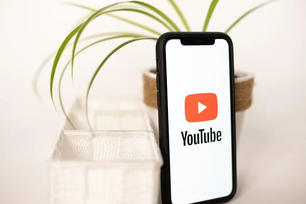 Phone showing the YouTube logo, guide to buy YouTube comments