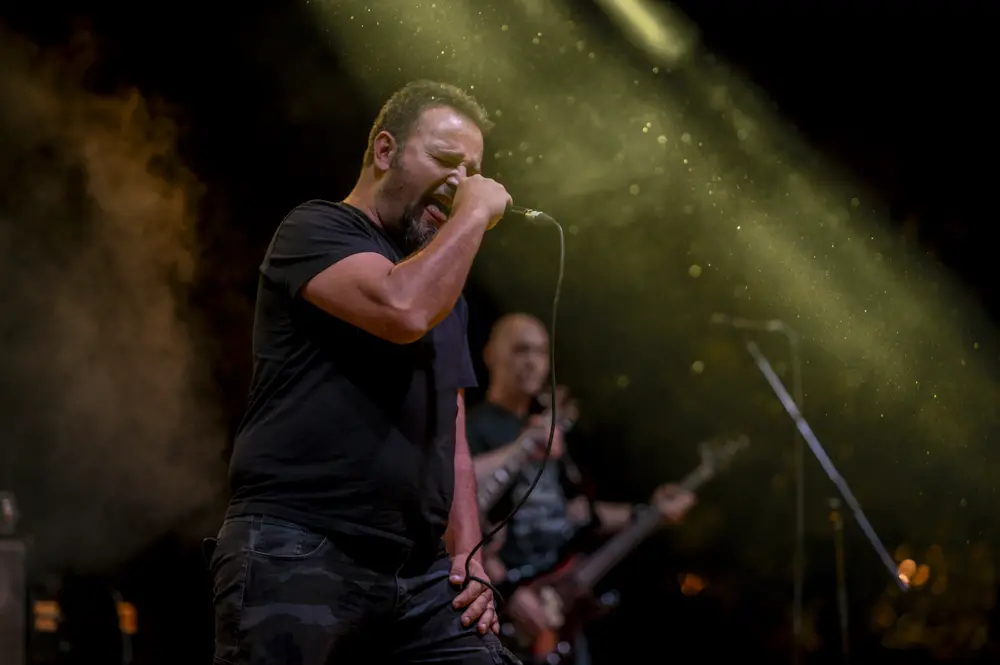 A singer performing under stage lights with a microphone, representing the kind of live music content shared on accounts like @livinloudwithmarc