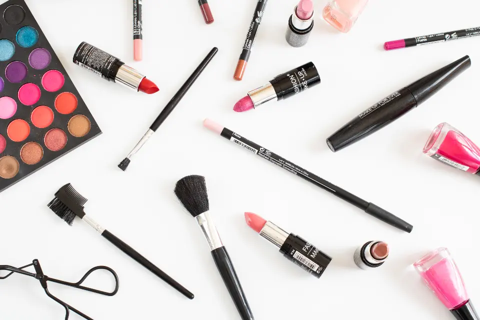 Colorful makeup products including lipstick, mascara and an eyeshadow palette laid out on a table, the kind of beauty content shared on Instagram in the US