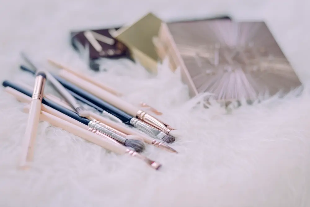 Makeup brushes and an eyeshadow palette laid out on a table, reflecting the kind of beauty and wellness content shared on Instagram
