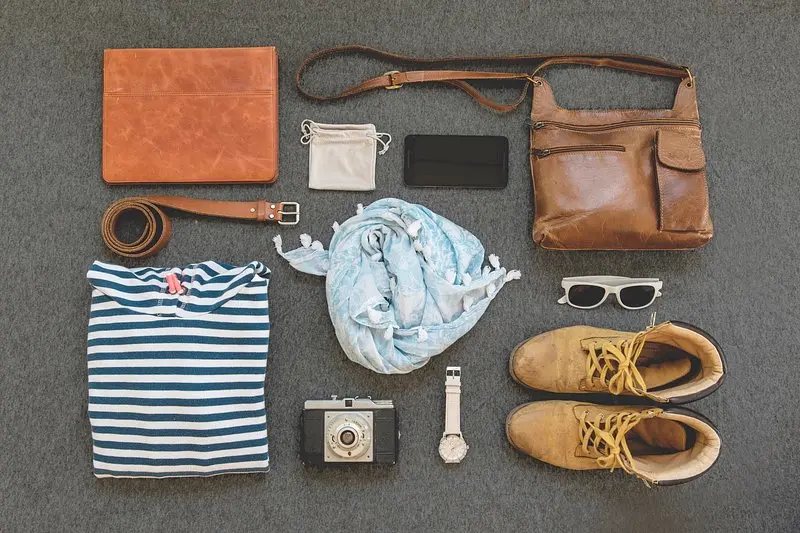 Flatlay of casual autumn outfit pieces, including a striped top, scarf, boots, and accessories, reflecting the everyday style content shared on Instagram