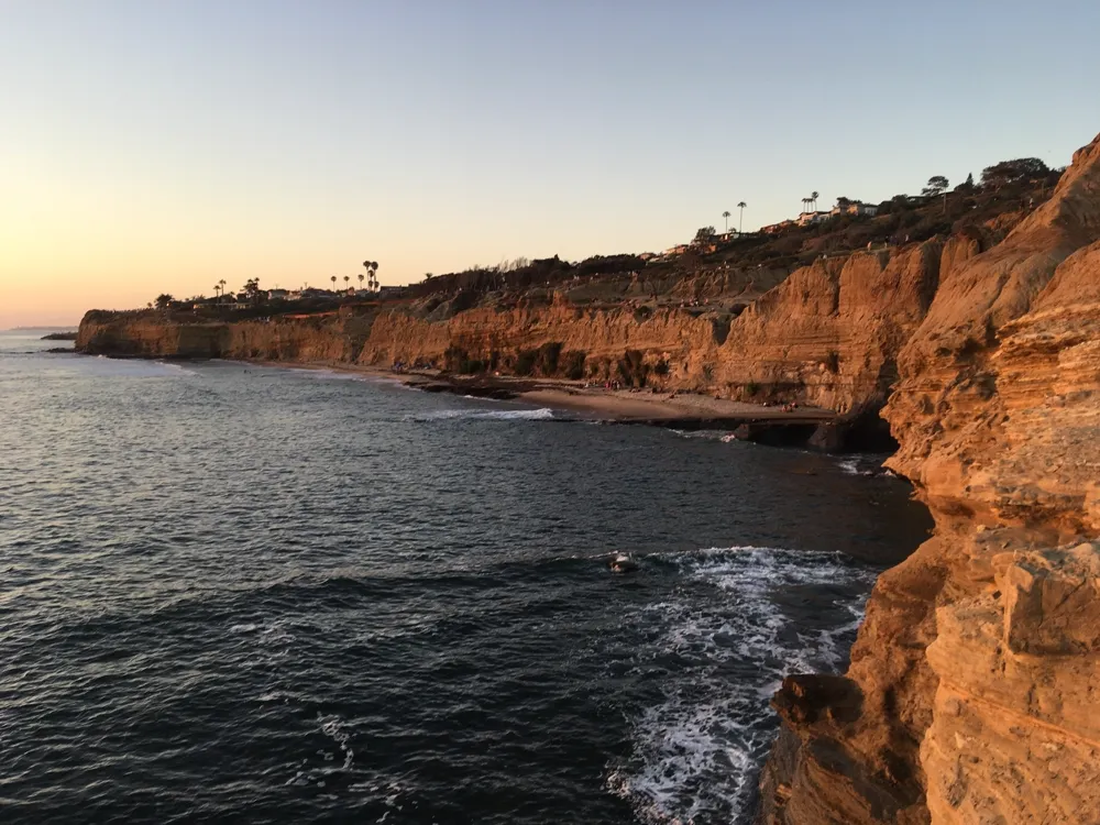 Sandstone sea cliffs along the San Diego coastline at sunset, the kind of California travel spot a local recommender would point you to