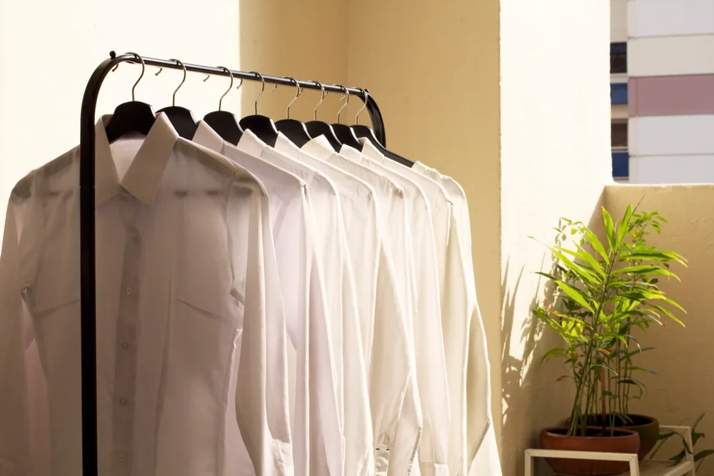 White button-down shirts hanging on a black clothing rack, illustrating workwear and office outfit content on Instagram in the US