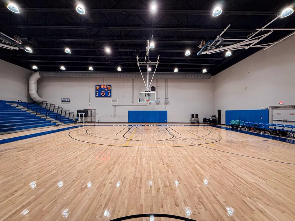Empty indoor basketball court with hardwood floor and bleachers, illustrating sports trivia content on Instagram in the US